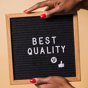 Hands holding a letter board with 'Best Quality' text, emoji, and thumbs up.
